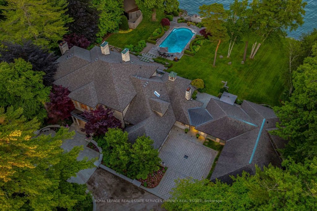 Aerial view of a luxury waterfront estate with a pool and mature trees in Oakville